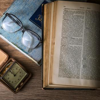 A book, glasses and a clock