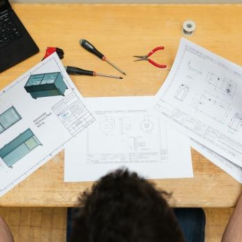 man looking at his work papers on a desk