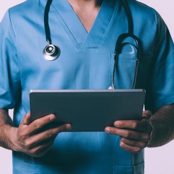 Male nurse with stethoscope and holding a patient chart