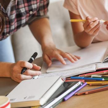 female education assistant and child working on drawings