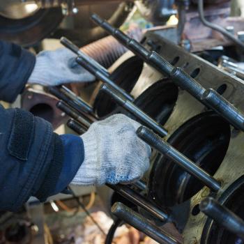 Mechanic's gloved hands fixing a diesel generator