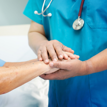 A Resident Care Worker, holding hands with a resident client.